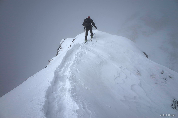 Skinning up a snowy ridge.